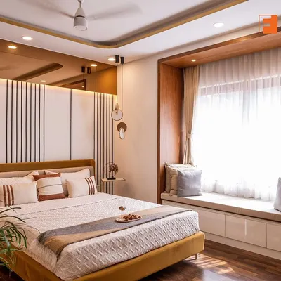 A sophisticated master bedroom featuring a stylish bed with a mustard-colored frame and a chic paneled headboard. The design includes a cozy window seat with built-in storage, perfect for relaxing with a book.