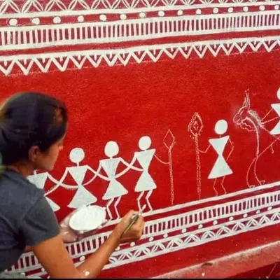 I love working with traditional art forms. Here I am painting a Warli mural, using its simple, geometric language to tell a story of community and celebration.