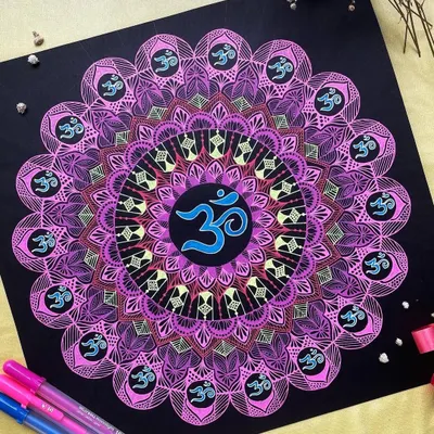 This 12-inch mandala features the sacred 'Om' symbol, drawn with vibrant gelly roll pens on black paper. The colors radiate outwards, creating a powerful spiritual artwork that brings a sense of peace and positive energy.