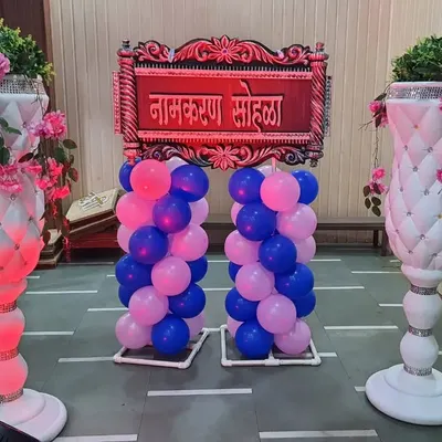 A traditional welcome sign for a 'Namkaran Sohala'. This entrance setup features a carved Marathi sign, balloon pillars, and illuminated vases to create an impressive welcome for your guests.