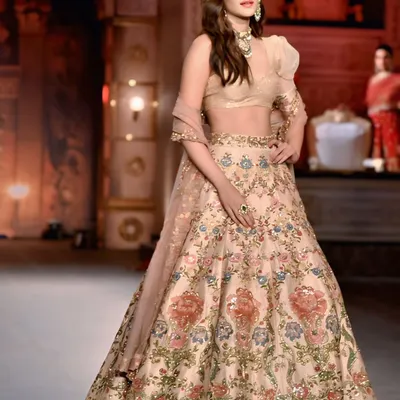 Actress Kriti Sanon owning the runway in a stunning embroidered lehenga. This shot captures her powerful presence and the exquisite detail of the couture.