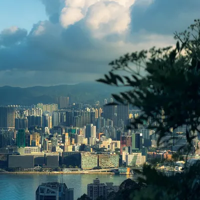 A view of the Hong Kong cityscape with dramatic clouds. The Aqua preset enhances the blues in the sky and water, creating a moody and powerful landscape.