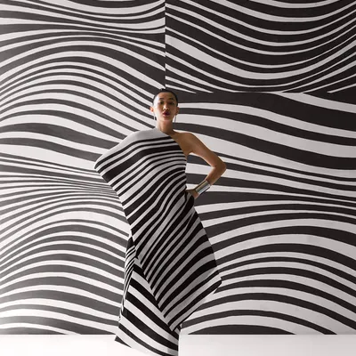 A striking image from a Payal Khandwala campaign, where the model's pleated dress merges with the optical art background. This is an example of creating a total work of art, not just a photograph.