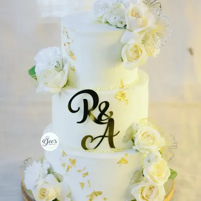 This three-tier all-white wedding cake is the definition of classic elegance. I adorned it with fresh white roses and delicate gold leaf accents for a timeless and sophisticated look.