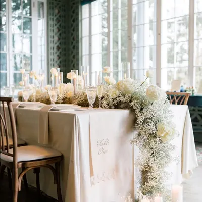 My basics are clear, no basic please. This elegant tablescape with a cascading baby's breath runner, candles, and fine tableware is the standard of sophistication I bring to my events.