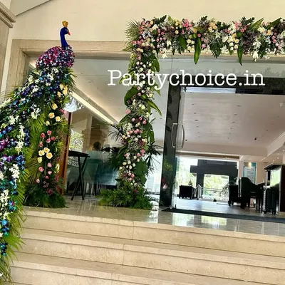 This grand entrance features a floral peacock sculpture with a long, cascading tail made of flowers, wrapping around the doorway. It's a spectacular welcome piece that immediately wows guests.