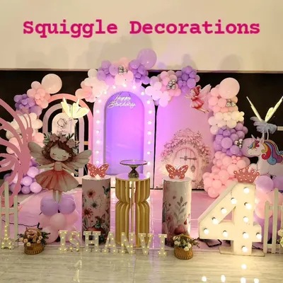 A truly enchanting butterfly-themed 4th birthday party. The setup includes large pink butterfly wings, a fairy cutout, a unicorn, and a beautiful purple and pink balloon arrangement.