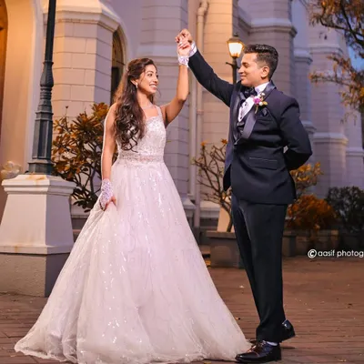 A dance with her prince charming. This beautiful couple is captured outside the church, showcasing the bride's stunning white ball gown and the groom's classic tuxedo.