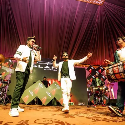 This shot perfectly captures our live dynamic. It shows our vocalist, dhol player, and me at the DJ console, all performing together to create that interactive musical experience we're known for.