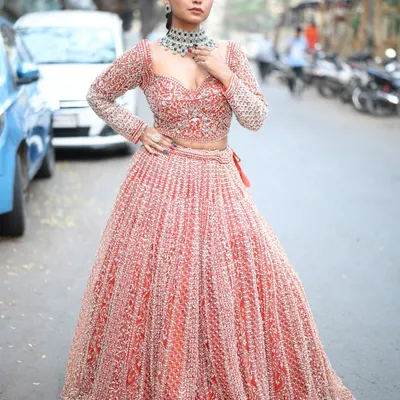 A full view of the gorgeous red and silver embroidered lehenga. The full-sleeve blouse and detailed skirt make it a truly regal choice for any bride or wedding guest.