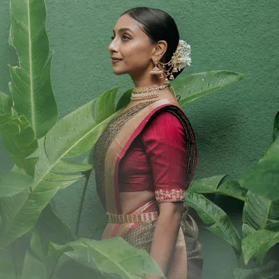 A stunning portrait of the bride, Harshitha, her traditional attire and serene expression perfectly complemented by the lush green backdrop of our gardens.