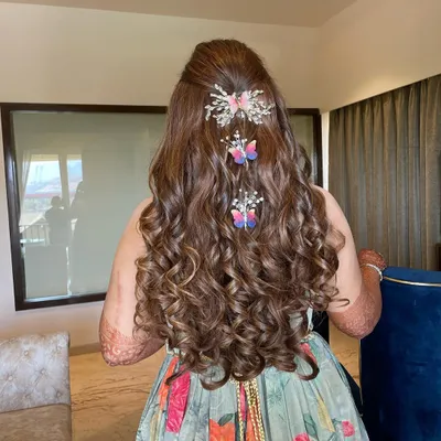 A whimsical and beautiful hairstyle for Hani's Mehendi. The long, flowing curls are decorated with delicate butterfly clips, creating a look that is both playful and elegant.