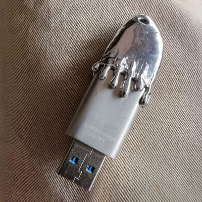 A custom-designed USB drive I made for my DJ sets. The top is a solid piece of silver with a melting, 'frostbite' effect. It’s a functional item that also serves as a piece of branding and personal style.