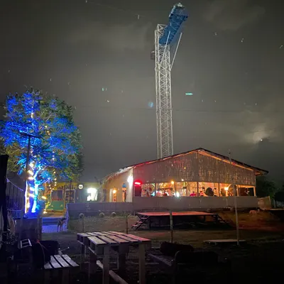 A stunning night view of our venue, prominently featuring the illuminated bungee jumping tower. This structure is central to our adventure offerings, providing a thrilling experience for daredevils.