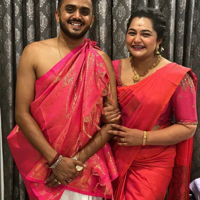 A happy client couple in their coordinated traditional outfits. I provided the custom-designed pink blouse for her to match his angavastram for their ceremony.