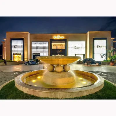 The facade of the DLF Emporio mall at dusk. The glowing storefronts of luxury brands like Louis Vuitton and Dior create a powerful statement of premium commercial real estate.