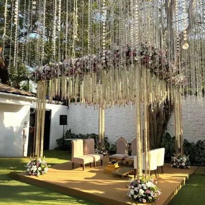 A closer look at a custom mandap designed to feel ethereal and light. The structure is adorned with a mix of pink and white florals, with delicate strings of flowers and crystals that catch the sunlight beautifully.