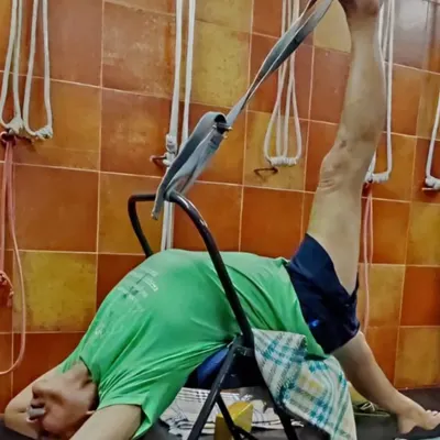 A demonstration of a supported leg stretch using a chair and strap. This variation of Supta Padangusthasana helps to open the hamstrings while keeping the back stable and supported.