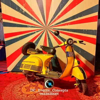 A fun and quirky retro-themed photo booth featuring a vintage yellow scooter against a vibrant sunburst backdrop. This is a great way to add an interactive and memorable element to any party.