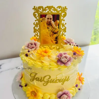 Celebrating the divine presence with sweetness and devotion. A beautiful yellow floral cake with a "Jai Guruji" blessing.