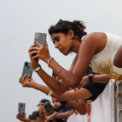 The crowd is as much a part of the show as the cars. Spectators line the rails, phones out, capturing every second of the action. This is the engaged audience your brand can connect with.