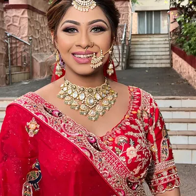 A beautiful, smiling bride ready for her big day. I created a classic bridal look with a defined eye, radiant skin, and a bright smile to match her stunning red lehenga.
