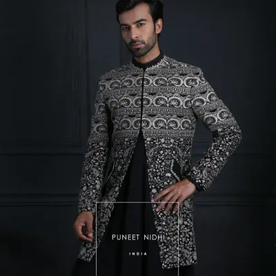 A structured black Achkan layered over a kurta, defined by a mandarin collar and sleek lines. Intricate silver embroidery cascades upward in floral and geometric patterns, offering a perfect fusion of tradition and contemporary style.