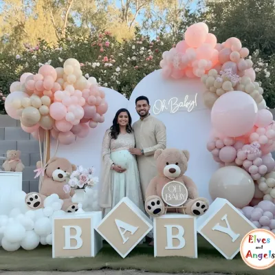 A beautiful couple at their 'Oh Baby' teddy bear themed baby shower. The outdoor setting with soft pink and neutral balloons created a warm and loving atmosphere.