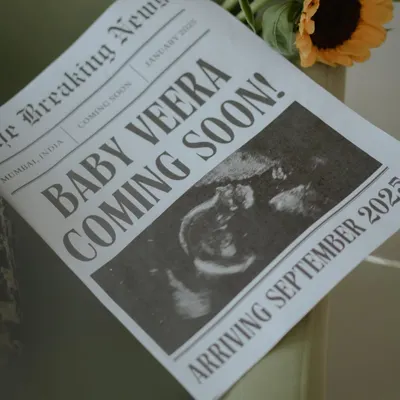 A close-up of the custom newspaper pregnancy announcement. Every detail, from the headline "Baby Veera Coming Soon!" to the sonogram picture, is designed to be a cherished keepsake of this special news.