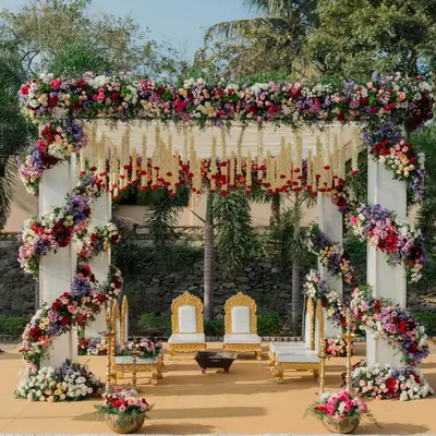 A breathtaking floral mandap, overflowing with colorful blooms and traditional hanging elements. This design creates a vibrant and sacred space for a Hindu wedding ceremony.