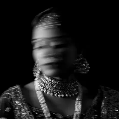 An abstract and artistic bridal portrait using motion blur. In black and white, this technique creates a ghostly and ethereal image, focusing on the form and jewelry of the bride.