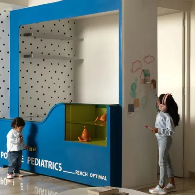 The centerpiece of the clinic's waiting area is this interactive "Plug & Play" unit. It provides a space for children to feel comfortable and engaged, with a whiteboard wall for creative expression.