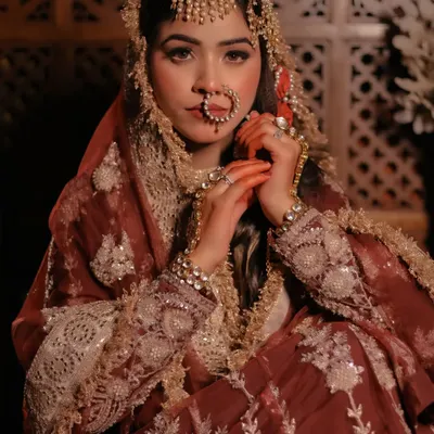 A royal portrait inspired by the grandeur of Heeramandi, featuring a model in a rich maroon outfit and elaborate passa jewelry.