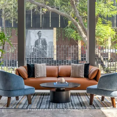 We designed this sales office lounge in Malad to be bathed in natural light. The comfortable leather sofa and modern armchairs create a relaxed yet sophisticated atmosphere for welcoming clients.