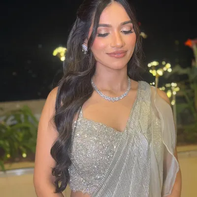 For this evening reception look, I styled the bride's hair in voluminous, soft waves. This half-up, half-down style keeps the hair away from the face while showcasing its beautiful length and texture.