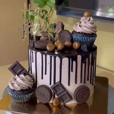 A decadent chocolate overload cake, topped with Oreos, chocolate bars, and cupcakes.