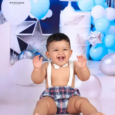 The pure, unfiltered joy of a first birthday cake smash. This little boy's happy expression and messy hands perfectly capture the fun of this milestone celebration.