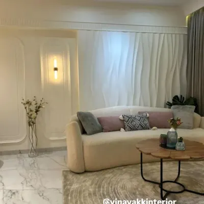 I believe in creating living rooms that are both serene and stylish. This space uses a soft, neutral palette, a plush curved sofa, and elegant 3D wall paneling to create a minimalist yet luxurious feel. The design focuses on texture and light to make the room feel warm and inviting.
