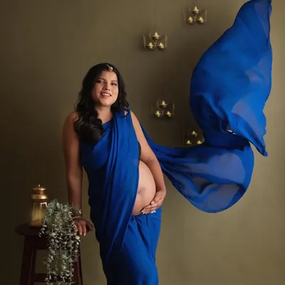 A full-length portrait showing off the beautiful flow of the royal blue saree. This style of maternity photography feels so graceful and timeless.