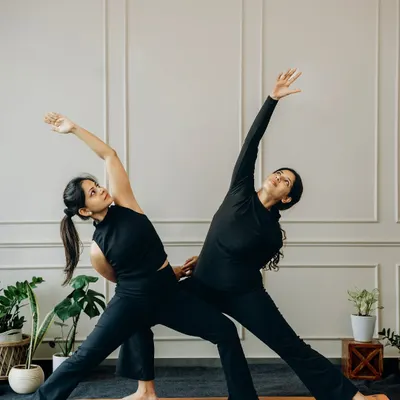 Two bodies, one rhythm. In partner yoga, every stretch is supported and every line is sharpened by alignment. Here, we explore a supported Trikonasana (Triangle Pose).