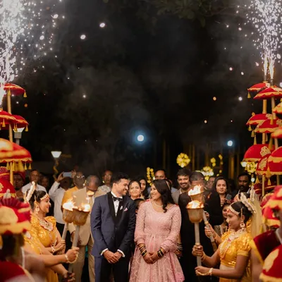This is the moment it all comes together. The happy couple makes their grand entrance, surrounded by the warmth of family, the sparkle of fireworks, and the traditional welcome of torchbearers, creating a truly cinematic memory.