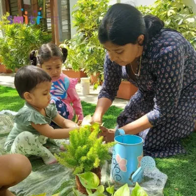 A teacher shows our toddlers how to care for a plant. These gentle introductions to gardening are part of our Exercises of Practical Life.