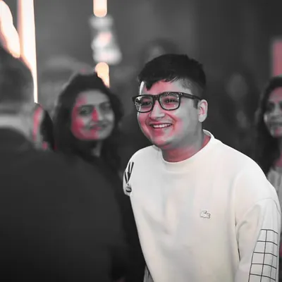 A candid black and white photo with a pop of red, capturing a genuine smile. It's the happy faces in the crowd that make it all worthwhile.
