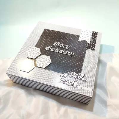 The cover of a stylish black and white anniversary gift box, which can be filled with a scrapbook and other goodies for him.