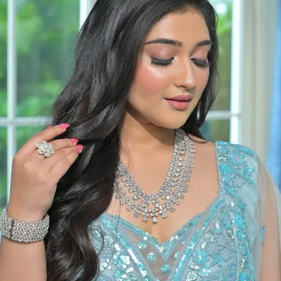 An ethereal look for a modern reception. This bride is wearing a stunning multi-layered diamond-look necklace with a matching bracelet and ring, paired with a sequined light blue lehenga.