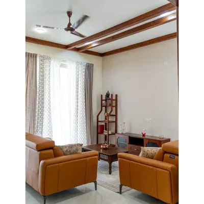 This living room is a symphony of textures and tones. The warm tan leather sofas, custom solid wood furniture, and elegant ceiling rafters create an intimate and luxurious space, perfect for welcoming guests or enjoying a quiet evening.