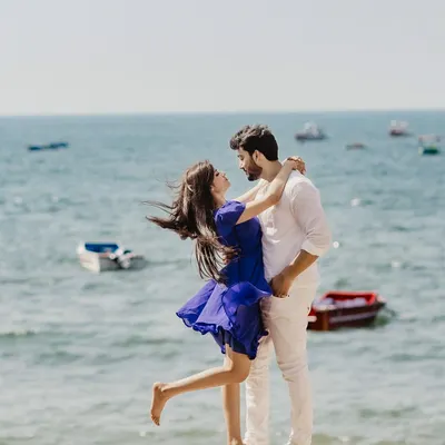 A breezy, romantic moment on the shores of Goa. The wind catching her hair and dress as they embrace by the sea creates a feeling of effortless, natural love.