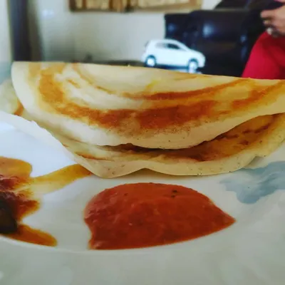 A classic plain dosa, cooked to a perfect golden-brown crisp and served with a side of spicy tomato chutney. A light yet satisfying meal.