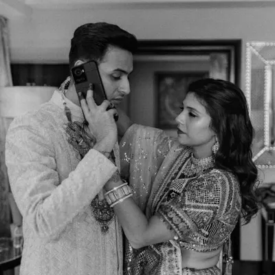 Even in the middle of wedding day chaos, a groom needs to look sharp. This candid shot captures a real moment while showing off the groom's elegant sherwani. My job is to make sure every detail is perfect, even when they're on an important call!