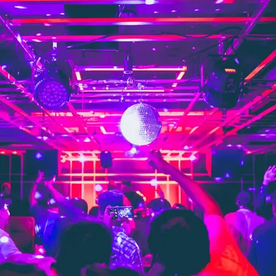 The quintessential club scene with a disco ball and vibrant purple lights at Gawky Goose. My sets are designed to match this classic party atmosphere, keeping the energy high all night.